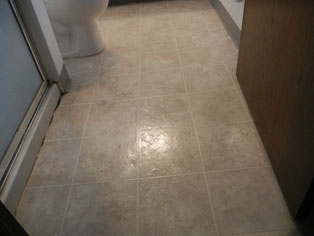 Before - Linoleum floor is worn, dated, and has water damage.